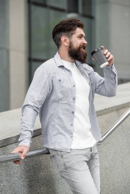 Gülümseyen adam sokakta kahve içiyor. Kahve içen bir adamın fotoğrafı. Adam dışarıda kahve içiyor. Adam dışarıda kahve içiyor..