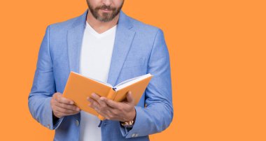 cropped studio shot of businessman holding planner. photo of businessman hold planner. businessman with planner isolated on yellow background. businessman with planner in jacket.
