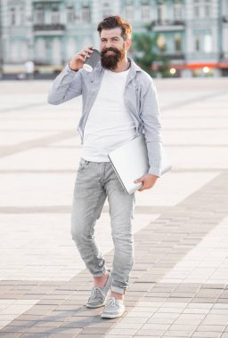 Adam sokakta yürürken akıllı telefondan konuşuyor. Akıllı telefondan konuşan adamın fotoğrafı. Adam dışarıda akıllı telefondan konuşuyor. Adam dışarıda akıllı telefondan konuşuyor..