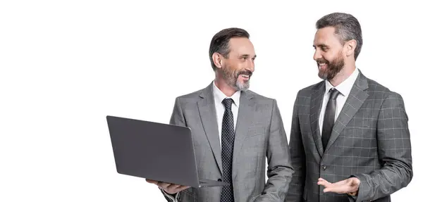 Stock image businessmen freelancing isolated on white background with copy space. businessmen freelancing in studio. photo of businessmen freelancing on laptop. two businessmen freelancing using laptop.