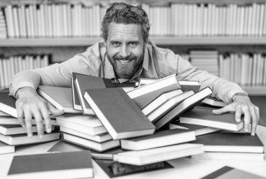 Öğretmen kitaplardan bilgi alır. Kitapçıdaki erkek öğretmen. Üniversite öğretmeni kitap okuyor. Okula dönüyorum. Kütüphanedeki öğretmen. Kitap seven adam eğitim alır. Bilginin gücü.