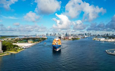 Miami Biscayne Körfezi 'nin silüeti. Miami güney sahili hava manzaralı. Kargo gemisi Biscayne Körfezi marinasına giriyor. Miami, Florida 'nın gökyüzü manzarası. Şehir merkezinin silüeti. Konteynırlı kargo gemisi.