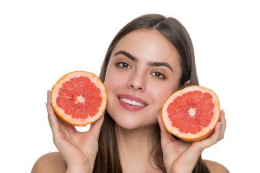 Kadın tenini bembeyaz vitaminle dolduruyor. Cilt bakımı ve diyet. Gençlik ve güzellik. Genç kız sağlıklı bir ışıltı için detoks yapıyor. Sağlıklı greyfurtlu genç bir kadın. C vitamininin faydaları. Cildi parlatır..