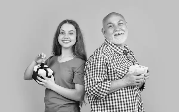 Stock image glad girl and granddad with present box for anniversary.