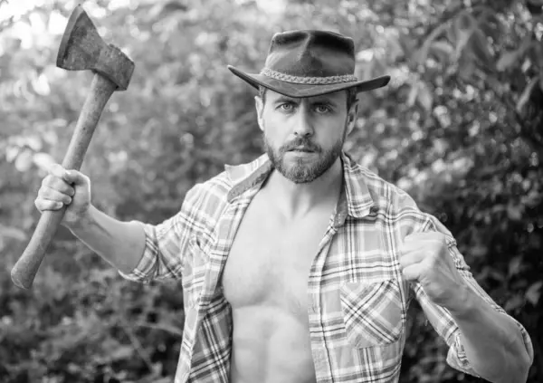 stock image angry lumberjack with axe. angry lumberjack with axe wearing checkered shirt. angry lumberjack with axe outdoor. photo of angry lumberjack with axe.