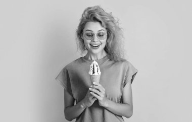 Dondurmalı bir yaz kadınının şaşırmış fotoğrafı. Dondurmalı yaz kadını sarıda izole edilmiş. Stüdyoda dondurmalı yaz kadını. Arka planda dondurma külahlı yaz kadını..