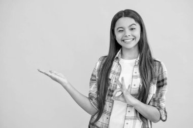 Genç kız yeni ürününü arka planda sunuyor, tamam mı? Genç kız kameraya ürünü sunuyor. Potansiyel müşterilere ürün sunan genç bir kız. İzleyicilere ürün sunan genç kız.