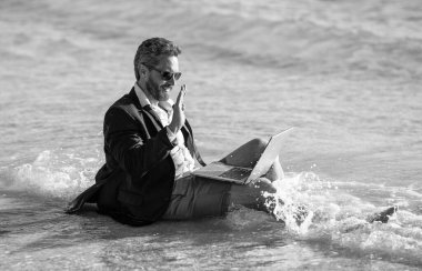 Yaz haftasonu ve uzak bağımsız çalışma. Bilgisayarlı bir iş adamı. İş adamı yazları denizde rüya görür. Yaz işi. Yaz tatilinde serbest çalışan bir iş adamı. Yenilenmek için seyahat.