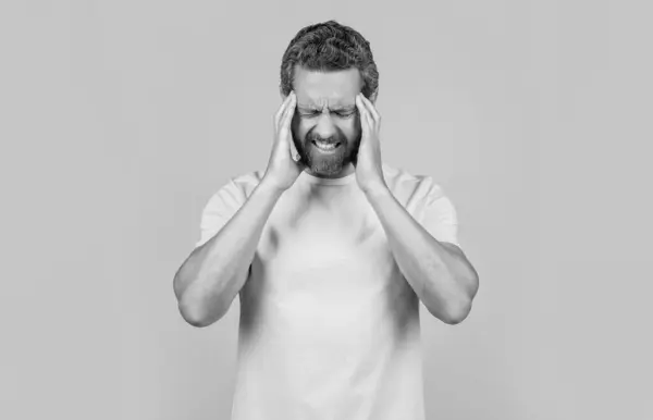 stock image man has headache on yellow background. man has headache in studio. photo of man has headache. man has headache isolated on yellow.