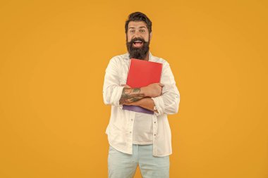 Stüdyodaki planlayıcısı ile milenyum adamı şaşırttı. Arkaplanda planlayıcısı olan bin yıllık bir adam. Milenyum adamı ve planlayıcısının fotoğrafı. Milenyum adamı planlayıcısı sarıda soyutlanmış..