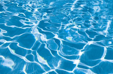 Yaz aylarında dalgalı yüzme havuzu suyunun mavi arkaplanı.