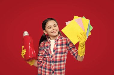 positive girl with softener detergent on background. photo of girl with softener detergent. girl with softener detergent isolated on red. girl with softener detergent in studio.