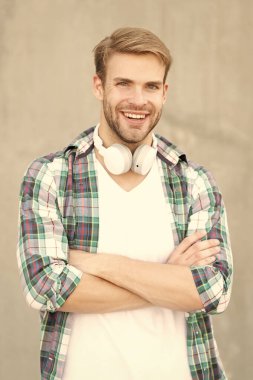 smiling man music lifestyle wearing checkered shirt. photo of man music lifestyle with headphones. man music lifestyle outdoor. man music lifestyle concept.