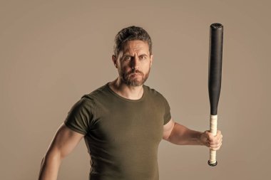 photo of angry aggressive man hold bat. angry man threatening. angry man express anger with bat isolated on grey background. aggression of angry man with bat in studio.