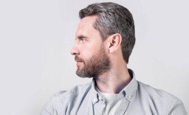 Stüdyoda sakallı sıradan bir beyaz adam profili. Kafkasyalı bir adamın resmi sıradan giyiniyor. Gündelik tişört giyen beyaz bir adam. Gri arka planda izole edilmiş günlük tarzda beyaz bir adam..