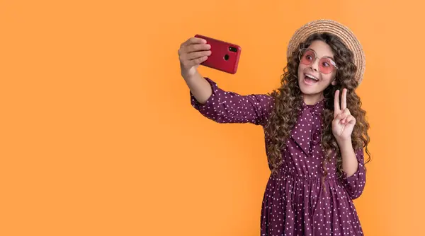 stock image amazed girl with curly hair taking selfie on phone.