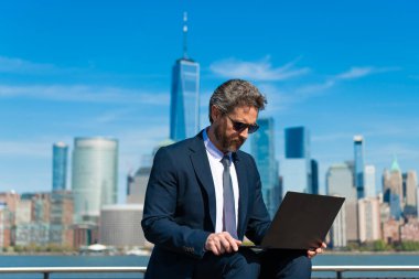 İnternette çalışan bir iş adamı. İş adamı dışarıda dizüstü bilgisayarla çalışıyor. Adam internet tarayıcısından iş e-postası ve sörf yolluyor. Dijital veri yönetimi. New York 'ta serbest çalışan bir iş adamı. Denetçi.