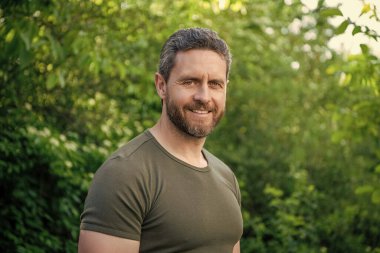 Gömlekli mutlu sakallı adam. Sakallı, beyaz bir adam. Olgun adam dışarıda.