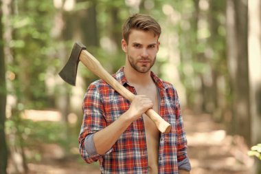 Oduncu tişörtlü oduncu omzunda balta tutuyor..