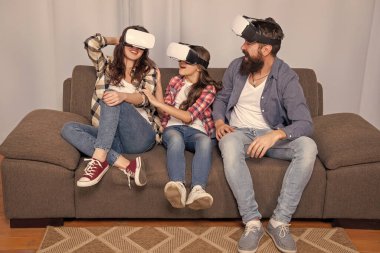 Sanal gerçeklik gözlüklü anne-baba ve kızı video oyunu.
