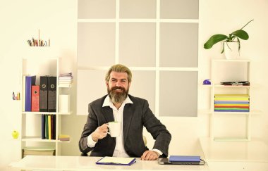 Kahve güzelmiş. Saygıdeğer CEO. Yakışıklı patron ofiste oturup kahve içiyor. Sakallı hippi kıyafeti kahveyle rahatlıyor. İlham verici ve motive edici. Ofiste sabah kahvesi. Ofis hayatı.