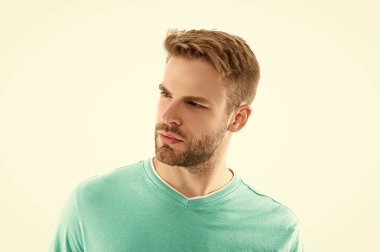 Tıraşsız yakışıklı bir adamın portresi. Traşsız bir adamın stüdyo fotoğrafı. Genç, tıraşsız bir adam yüzü beyaz arka planda izole edilmiş. Tişörtlü traşsız bir adamın yüzü..