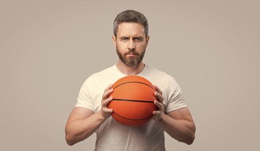 Basketbolcu ve topçunun fotoğrafı. Spor giyim sektöründe basketbol oyuncusu. Sporcu basketbolcu gri arka planda izole edilmiş. Stüdyoda basketbol oyuncusu.