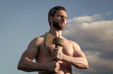 Baltalı üstsüz adam. Beyaz adam, baltayı tut. Arka planda vahşi bir adam. Güç ve güç.