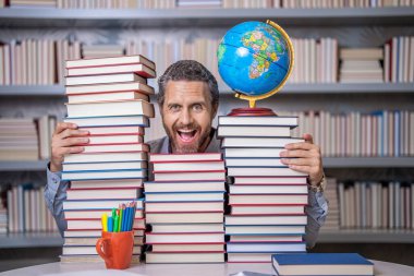 Ders kitabı olan inek bir adam. Okul edebiyat eğitimi. Sınıftaki inek adam. Okul kütüphanesinde kitap kurdu. Eğitim ve bilgi. Sınıftaki erkek öğretmen. Okul eğitimi. Okuma alışkanlıkları.