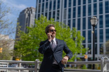 İş iletişimi. İş adamının dışarıyı araması gerekiyor. Telefon kullanan bir iş adamı. Takım elbiseli bir adam telefonda konuşuyor. Telefonu olan orta yaşlı İspanyol işadamı. Toplum önünde konuşma.