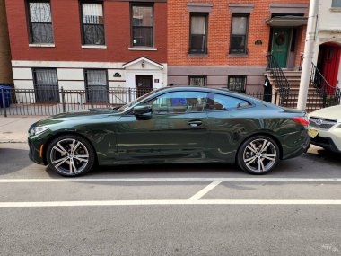 New York City, ABD - 27 Şubat 2024: BMW 4 lüks araba caddeye park edilmiş, yan manzara.