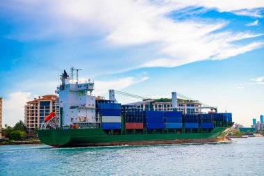 Miami 'de konteynırlı bir kargo gemisi. Miami Limanı 'ndaki konteynır. Limanda konteynırla yük gemisi mavnası. Florida 'da kargo gemisi. Biscayne Körfezi 'nde mavnası olan Miami plajı. Kargo gemisi lojistiği.