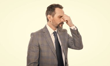 Takım elbiseli olgun iş adamı beyazda izole edilmiş. Baş ağrısı ve göz yorgunluğu. Kronik baş ağrısı. Aşırı çalışma ve hüsrandan dolayı migren ağrısı. Başı ağrıyan takım elbiseli bir iş adamı. İş adamı streslidir..