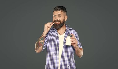 Mutlu olgun adam gri arka planda vitamin hapı alıyor..