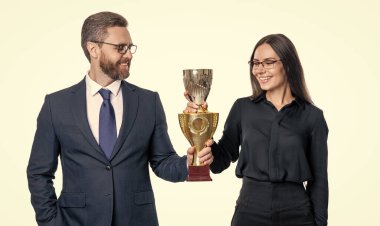 Takım elbiseli başarılı iş kadını adam şampiyonluk kupasını tutuyor. İş ödülü ve başarı. İş başarısı. İki iş adamı ve iş kadını başarılı bir toplantı yapıyorlar. başarıya giden yol.