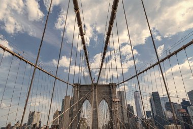 Brooklyn 'deki tarihi köprünün mimarisi. Amerikan mimarisi tarihi eser. Manhattan 'a giden yol. New York 'taki Brooklyn Köprüsü. Metropolis 'teki gökdelenlerin üzerindeki Brooklyn Köprüsü manzarası. İnanılmaz manzara.