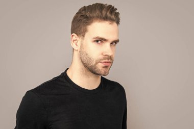 Stüdyoda sakallı bir adamın portresi. Gri arka planda sakallı bir adam var. Sakalı olan beyaz bir adamın yüzü. kıllar ve sakallar.