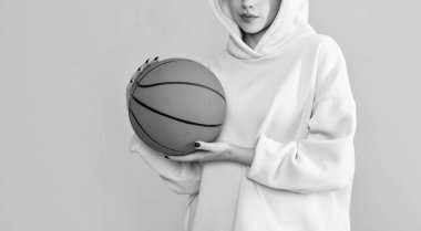young girl student with basketball ball on yellow background.
