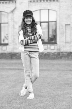 smiling teen girl model keeping arms crossed. teen fashion style. teen child standing outdoors.