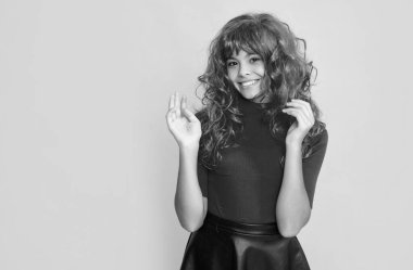 Sarı arka planda kızıl uzun saçlı çocuk gülüşü.