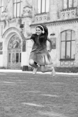 positive teen girl in headphones. girl jump outdoor. carefree girl jumping feel happiness.
