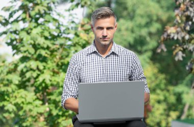 mature man working on laptop. man freelancer outdoor. business man with pc.