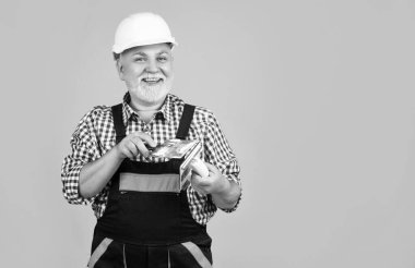Sarı arka planda kasklı, olgun bir adam..