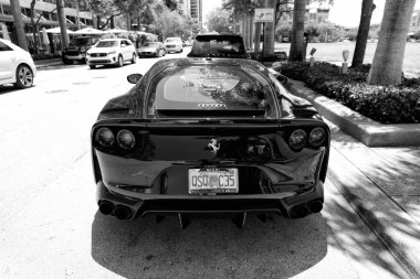 Miami Beach, Florida USA - April 15, 2021: black ferrari F12 berlinetta supercar, back view.