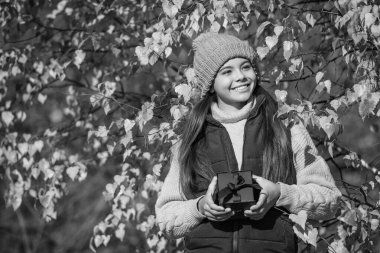 happy teen child with gift box in autumn. copy space.