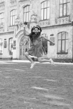 amazed teen girl in headphones. girl jump outdoor. carefree girl jumping feel happiness.