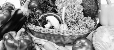 Variety of fresh ripe organic vegetables and leafy greens in basket close view.