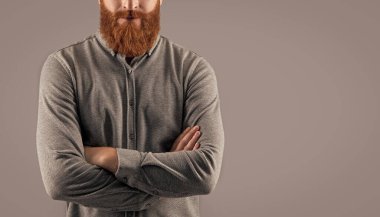 Confident man crop view with long beard. Unshaven face with red beard and mustache. Bearded and mustached Irish male studio isolated on grey, copy space.