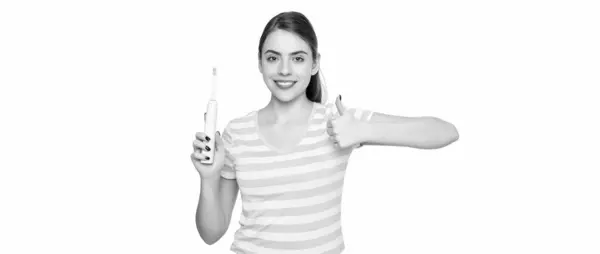 stock image cheerful young woman with electric toothbrush isolated on white background. thumb up.