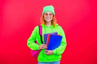 Okula dönelim. Bilgi toplama günü. Üniversitede eğitim. Pembe üzerine izole edilmiş bir kızın ödevi. Bilgi ve eğitim. Okul eğitimi. Modern eğitim. Kız öğrenci çalışma kitabını tutuyor. Bilgi tabanı.